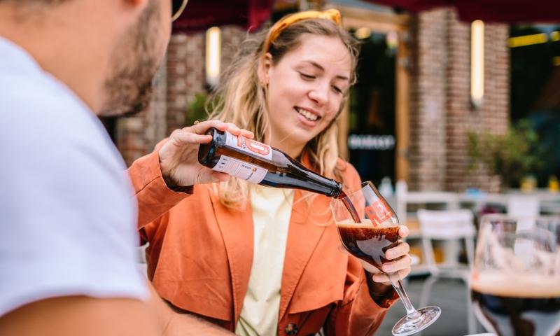 Meisje schenkt RED by Petrus in terwijl man toekijkt